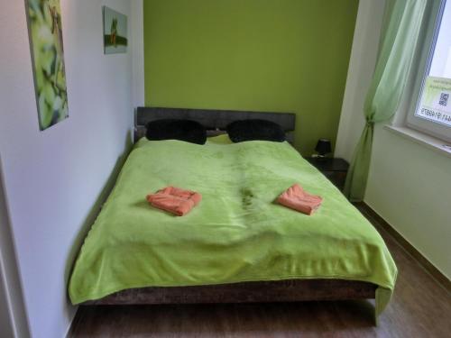ein Bett mit grüner Bettwäsche und zwei Kissen darauf in der Unterkunft Ferienwohnung KWi 73 EG "grüne Oase" in Graal-Müritz