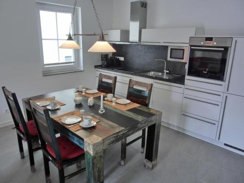 une cuisine avec une table et des chaises et une cuisine avec un évier dans l'établissement Ferienwohnung LP6, à Graal-Müritz