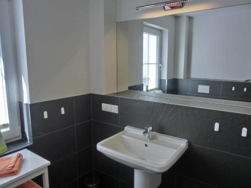 La salle de bains est pourvue d'un lavabo et d'un miroir. dans l'établissement Ferienwohnung LP6, à Graal-Müritz