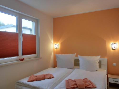 een slaapkamer met 2 bedden en een raam bij Ferienwohnung KWi 72 EG - "Kleine Fluchten" in Graal-Müritz