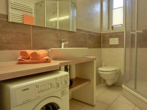 een badkamer met een wasmachine en een wastafel bij Ferienwohnung KWi 72 EG - "Kleine Fluchten" in Graal-Müritz