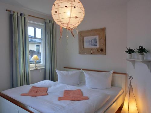 um quarto com uma cama branca com duas toalhas em Ferienwohnung K34 "Sonnenschein" em Graal-Müritz