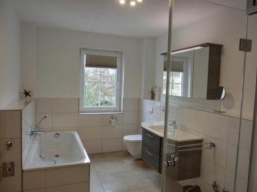 uma casa de banho branca com um lavatório e um WC em Ferienwohnung LP7 "Seestern" em Graal-Müritz