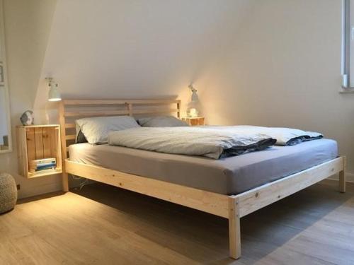 ein Schlafzimmer mit einem Bett mit einem Holzrahmen in der Unterkunft Ferienwohnung H 20 in Graal-Müritz