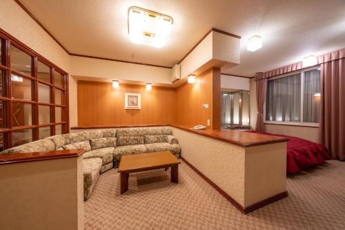 a living room with a couch and a table at Hotel Liberte Asahikawa in Asahikawa