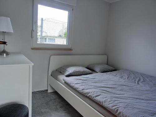 a bed in a white room with a window at Ferienhaus FH20 in Graal-Müritz
