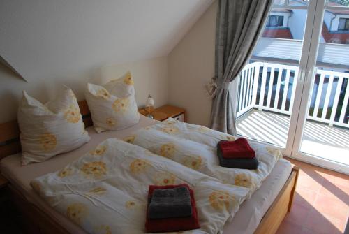 1 dormitorio con cama con almohadas y ventana en Ferienwohnung K38 "Sonnenblume", en Graal-Müritz