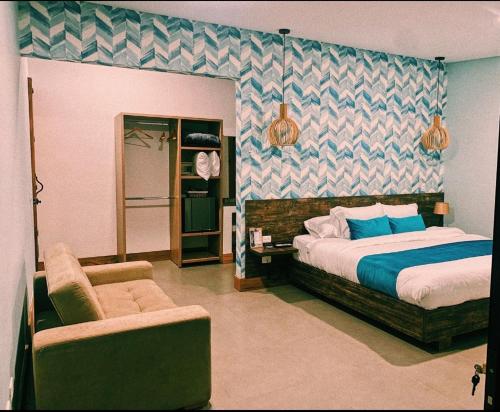 a bedroom with a bed and a chair at Casa Hotel Bremen in Circasia