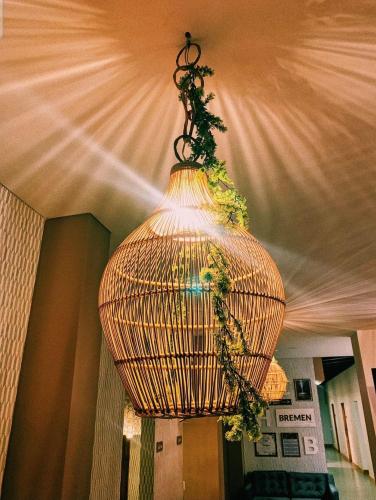 a large wicker chandelier hanging from a ceiling at Casa Hotel Bremen in Circasia