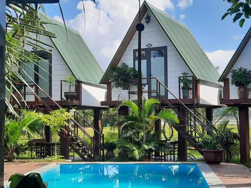a house with a swimming pool in front of it at Hưng Phát Bungalow in Phong Nha