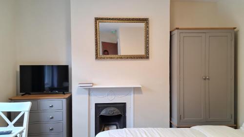 a bedroom with a mirror and a fire place at Grace Apartments - Living Rock in Ashford