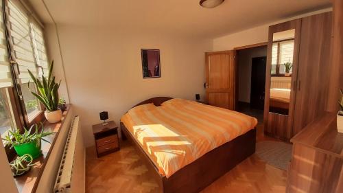 - une chambre avec un lit et une couverture orange dans l'établissement Apartment Aurelio, à Zenica