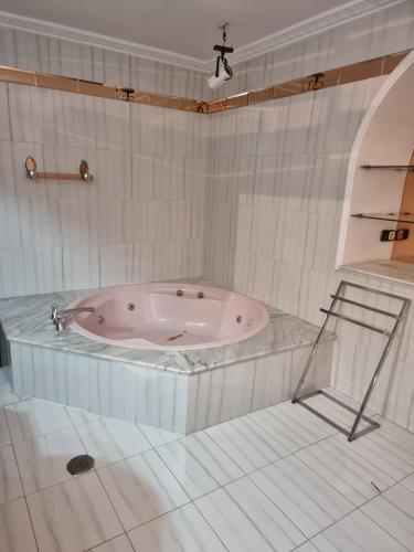 a bath tub in a white tiled bathroom at CASA en el CENTRO DE RONDA in Ronda