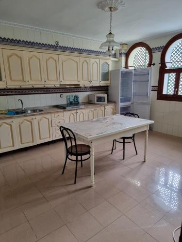 a large kitchen with a table and two chairs at CASA en el CENTRO DE RONDA in Ronda