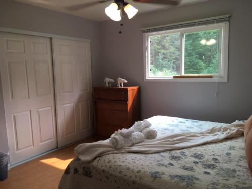a bedroom with a bed with white sheets and a window at Thunder Mountain Place - Quiet, Comfortable Place Offering DISCOUNT ON TOURS! in Juneau
