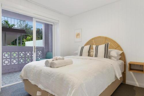 a white bedroom with a large bed and a window at Sunset Beach in Brunswick Heads