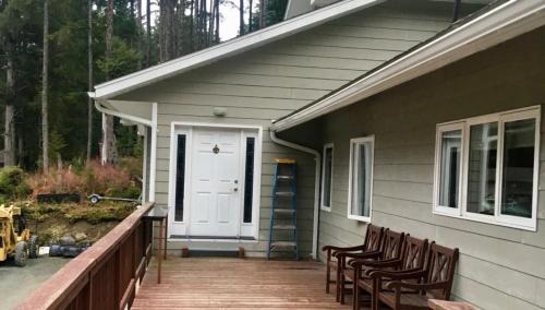 a porch of a house with chairs and a white door at Shangri-La - Near Mendenhall Glacier and Auke Bay -DISCOUNTS ON TOURS! in Mendenhaven