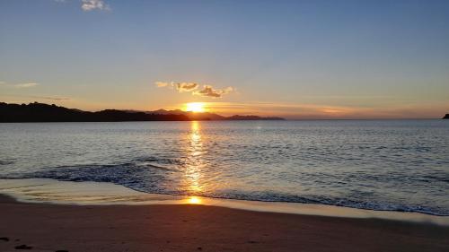 a sunset on a beach with the ocean at Villa Prados del Rio - Guanacaste, Costa Rica in Comunidad