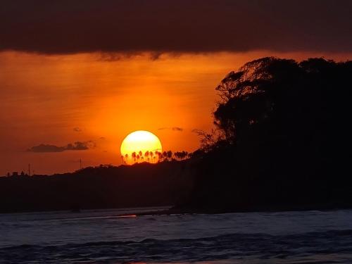 a sunset over the ocean with the sun in the background at Chalé 17 - Porto do Sol - Pipa in Pipa