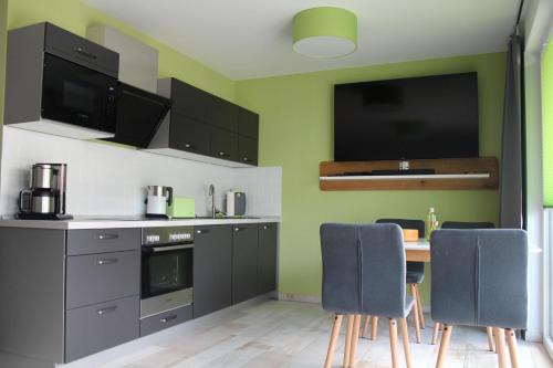 a kitchen with a table and blue chairs in it at Ferienwohnung KWV11EG "Seefrosch im Küstenwald" in Graal-Müritz