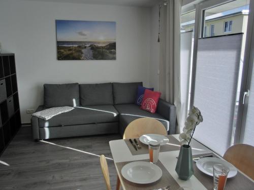 ein Wohnzimmer mit einem Sofa und einem Tisch in der Unterkunft Ferienwohnung KWi 84 EG in Graal-Müritz