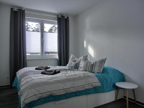 Schlafzimmer mit einem Bett und einem Fenster in der Unterkunft Ferienwohnung KWi 84 EG in Graal-Müritz