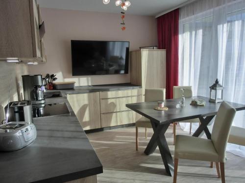 uma cozinha com uma mesa de jantar e uma televisão em Ferienwohnung KWV 7 EG em Graal-Müritz