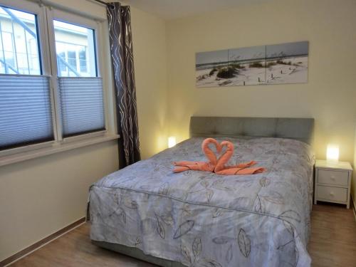 um quarto com uma cama com dois flamingos em Ferienwohnung KWV 7 EG em Graal-Müritz