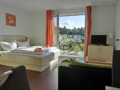 um quarto com uma cama e uma varanda com uma televisão em KW21 "Südwind 2" em Graal-Müritz