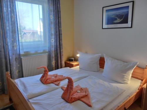 zwei Gummivögel, die in einem Schlafzimmer auf einem Bett sitzen in der Unterkunft Ferienwohnung E1 in Graal-Müritz