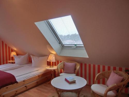 a bedroom with a bed and two chairs and a window at Ferienhaus FH1 in Graal-Müritz