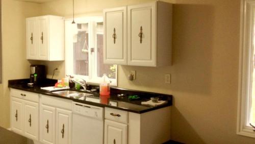 a kitchen with white cabinets and a sink and a window at Mendenhall Private Room In Shared Home - DISCOUNT ON TOURS in Mendenhaven