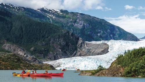 a group of people in canoes in the water near a glacier at Trailhead Room - Near Mendenhall Glacier, Trails, and Conveniences - DISCOUNTS ON TOURS! in Mendenhaven