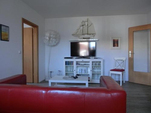 a living room with a red couch and a tv at Ferienwohnung P20 "Badenixe" in Graal-Müritz