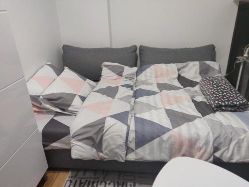 a bed with pillows on it in a room at Apartman Lori M in Kraljevo