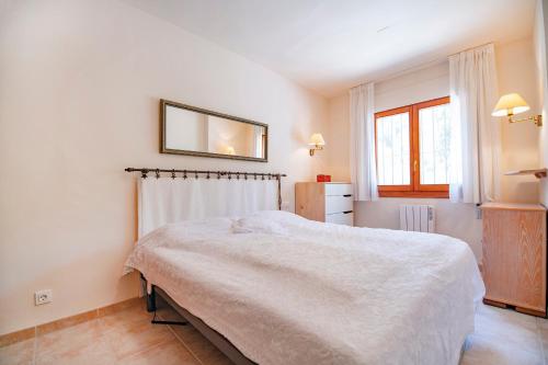 une chambre avec un lit et un miroir au mur dans l'établissement Palmyra - Sea view, chill-out - by Holiday Rentals Villamar, à Moraira