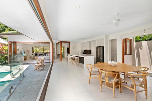 a kitchen and living room with a table and chairs at Bird of Paradise Holiday Home with Heated Pool in Palm Cove