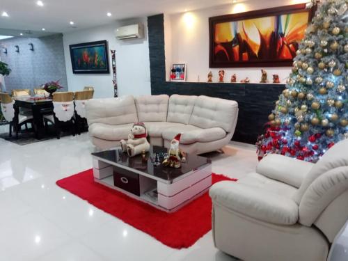 a living room with a christmas tree and white furniture at Casa Boutique HNP in Barrancabermeja