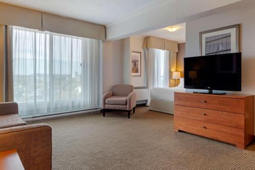 a hotel room with a bed and a flat screen tv at Best Western Plus Gatineau-Ottawa Downtown in Gatineau