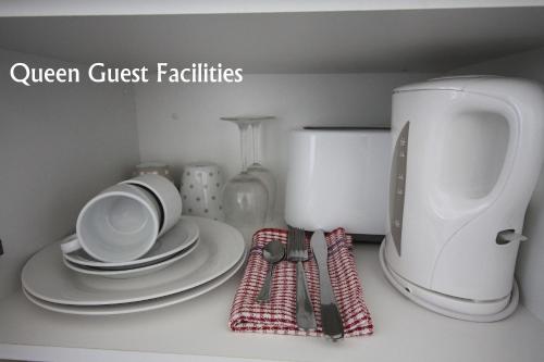 a kitchen counter with plates and a coffee maker at Hi Way Motor Inn in Yass