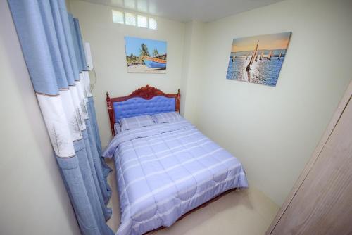 a bedroom with a blue bed and a picture on the wall at Mailz Haven #5 New Homey Apartment 750m near SM in Davao City