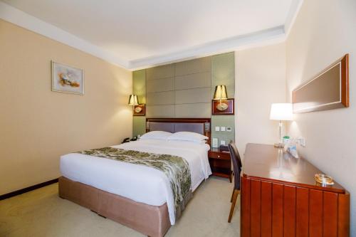 a hotel room with a bed and a desk at Yun-Zen Century Hotel in Shijiazhuang