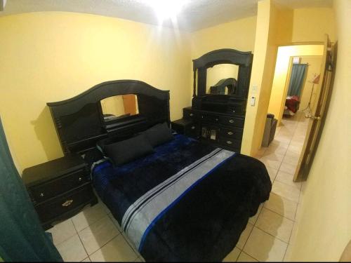 Schlafzimmer mit einem Bett, einer Kommode und einem Spiegel in der Unterkunft Casa Vicky Alojamiento para vacaciones y trámites consulares in Ciudad Juárez