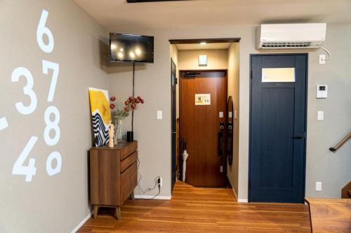 a hallway with a blue door and a room with a door at HAKATA TERRACE -灯 akari- in Fukuoka