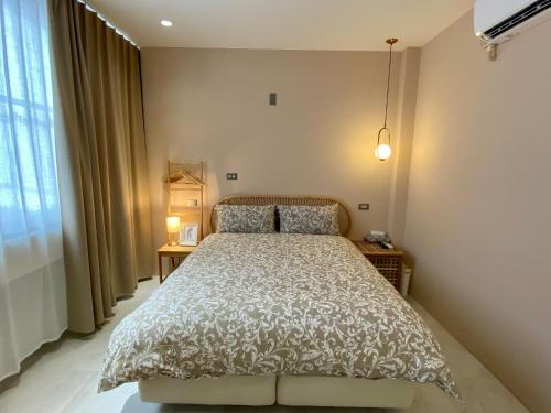 a bedroom with a bed with a white comforter at 安平言寓包棟旅宿 Ian Apt in Tainan