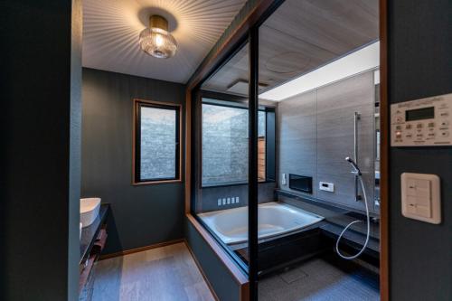 ein Bad mit einer Badewanne und einem Fenster in der Unterkunft HAKATA TERRACE -晴 hare- in Fukuoka