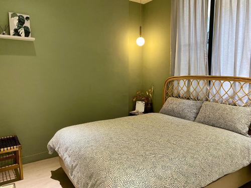 a bedroom with a bed and a green wall at 安平言寓包棟旅宿 Ian Apt in Tainan