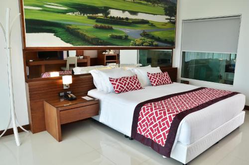 a bedroom with a bed and a painting on the wall at The Par Phuket SHA Plus in Kathu