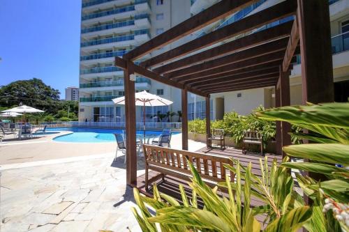 eine Terrasse mit einer hölzernen Pergola und einem Pool in der Unterkunft FLAT RIO STAY in Rio de Janeiro