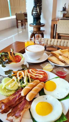 een bord met eten, eieren en vleeswaren op tafel bij La Mai Hotel in Chiang Mai